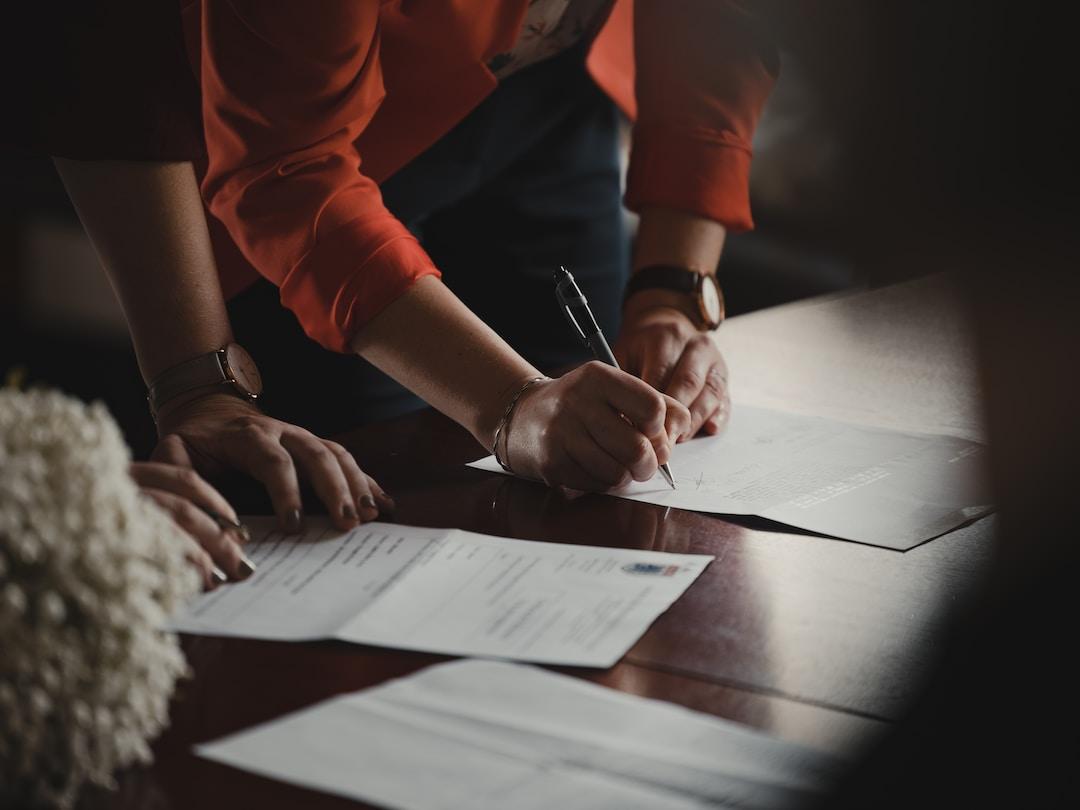 Two people filling out paperwork for a motorcycle accident lawsuit on a desk